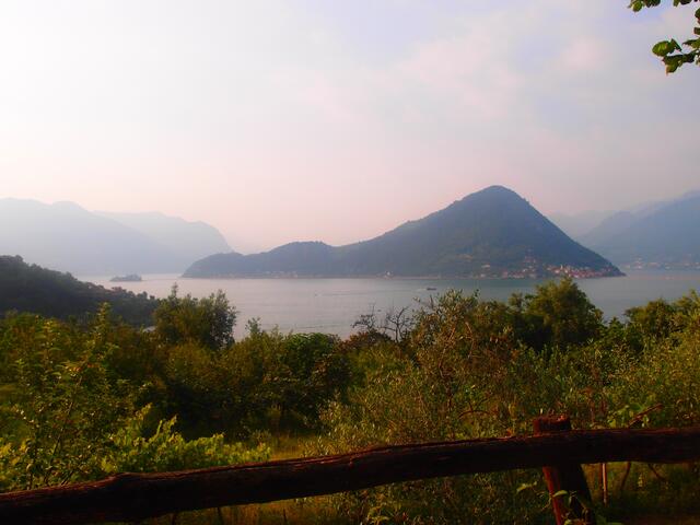Blick von der via valeriana :Monteisola, größte Binnenseeinsel Europas, links floating piers zur kl. Isola di San Paolo, rechts Steg, der Sulzano mit dem Monteisola verbindet: ein leuchtend orangefarbenes Band.
