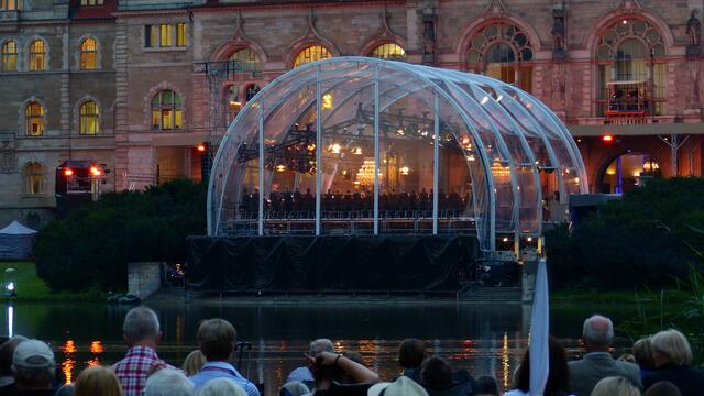 Die Bühne sehen wir von der Rückseite. Aber den Ton kann man überall hören.