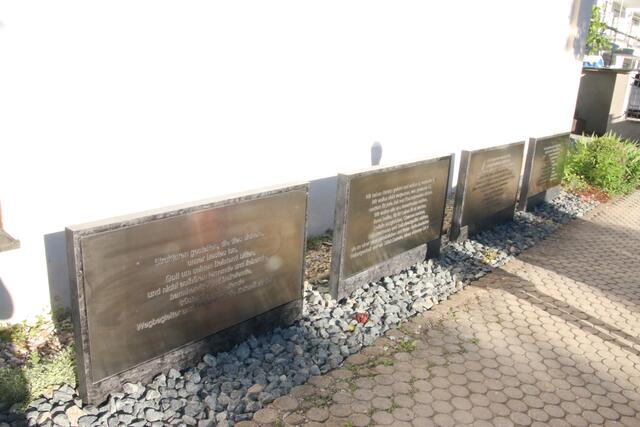 Hinter dem Mahnmal stehen die Gedenksteine mit den Aufschriften.