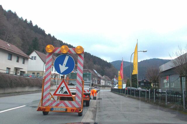 Ein weiterer Mitarbeiter der Privatfirma reinigt per Hand die Wassereinläufe vor einem Sicherungsfahrzeug am 06.04.2016.