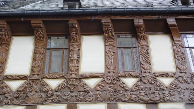Die Schnitzereien im oberen Balkenwerk zeigen auf ironische Weise mystische Szenen. Oben in der Mitte die berühmte "Butterhanne".