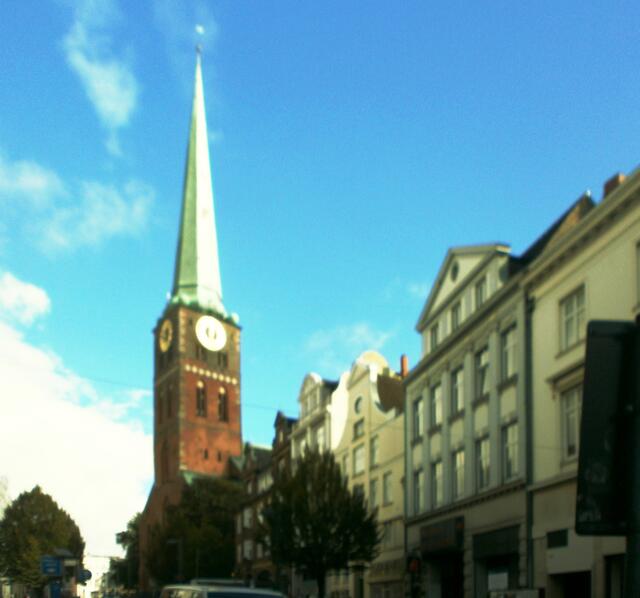Wir sehen die Jacobikirche. St. Jakobi ist eine der fünf Hauptkirchen der Lübecker Altstadt. Sie wurde 1334 als Kirche der Seefahrer und Fischer geweiht. Seit 2007 ist die nördliche Turmkapelle der Kirche Nationale Gedenkstätte für die zivile Seefahrt. Dort befindet sich eine Gedenkstätte für die auf See gebliebenen Lübecker Seeleute. Hier steht auch das Wrack eines Rettungsbootes der 1957 gesunkenen Viermastbark Pamir. Bei deren Untergang kamen 80 der 86 Besatzungsmitglieder ums Leben. St. Jakobi blieb als
