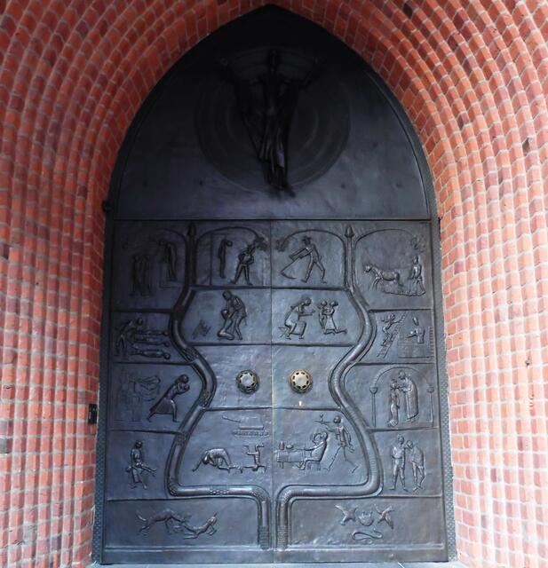 Am Eingangsportal der im Krieg schwerbeschädigten und ebenfalls wiederaufgebauten Marktkirche schuf der Bildhauer Gerhard Marcks 1959 eine neue Bronzetür. Auf dem linken Türflügel werden Szenen aus der Zeit der Nationalsozialisten dargestellt. Auf der rechten Szenen eines friedlichen Lebens.