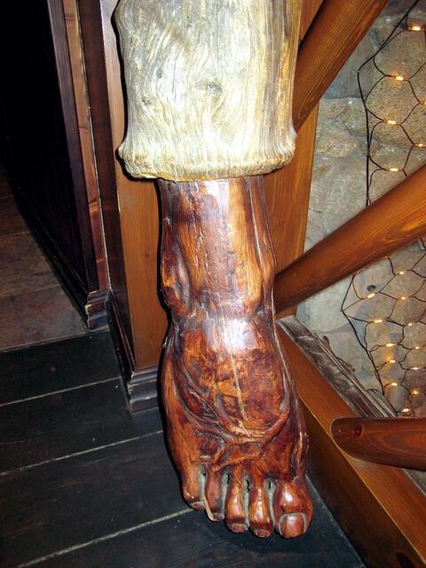 Da guckt ein Fuß aus einer Hose, die ein Baumstamm ist.