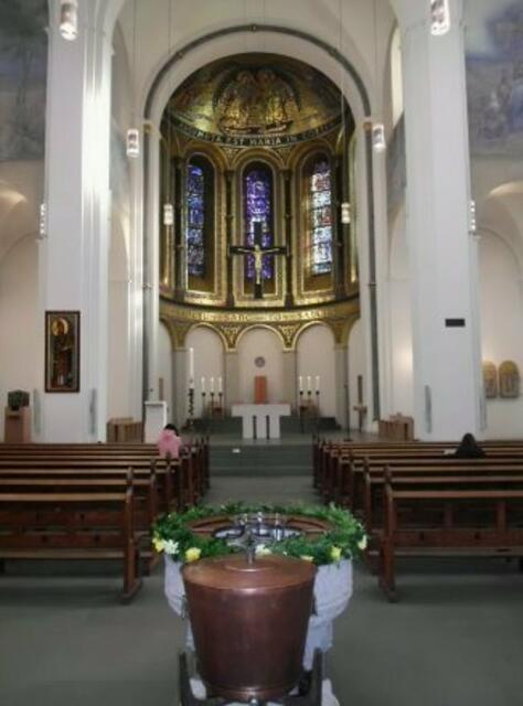 Inneres des neuromanischen Mariendoms. Im Chor Mosaik der Aufnahme Mariens in den Himmel (Assumpta est Maria in caelum). In der Mitte der Kirche steht der Taufbrunnen, der alle Gläubigen an die eigene Taufe erinnern soll.