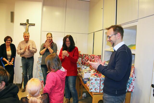 Carsten Unger, der stv. Gesamtleiter der Kinder-, Jugend und Familienhilfe Hochzoll (rechts) freut sich mit Tanja Schnepp, der Vorsitzenden des Vereins Kinderweihnachtswunsch und der Kolpingsfamilie Gersthofen über strahlende Kinderaugen bei der Geschenkeübergabe.