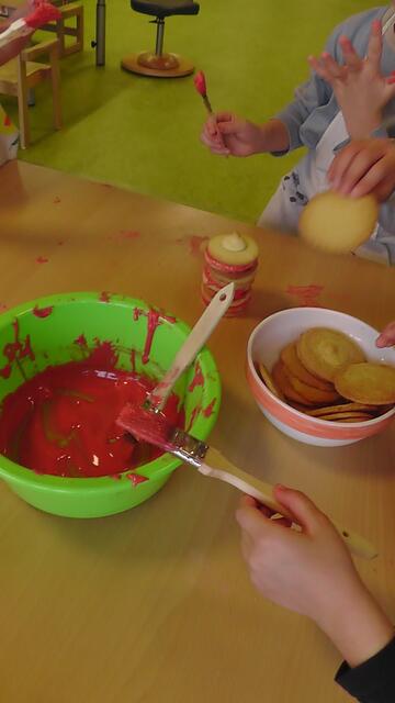 Was für eine Kleckerei - viele leckere Plätzchen werden mithilfe von Zuckerguss zu "Kerzen" zusammengeklebt.