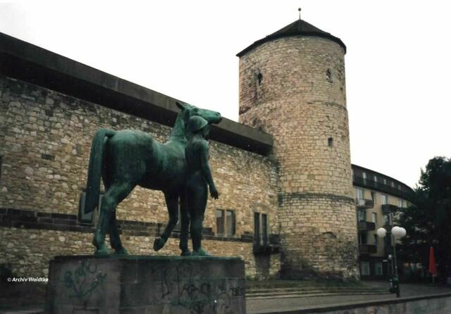 Die Bronzeplastik "Mann mit Pferd" von Hermann Scheuernstuhl vor dem ehemaligen Zeughaus und dem Beginenturm erinnert an die Pferdeschwemme an der Leine (Foto: Archiv Woidtke 1980er Jahre)