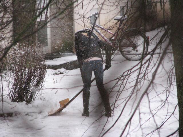 Anwohner räumen vor dem Haus den Schnee weg