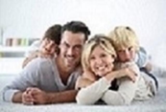 Portrait of happy family laying on carpet