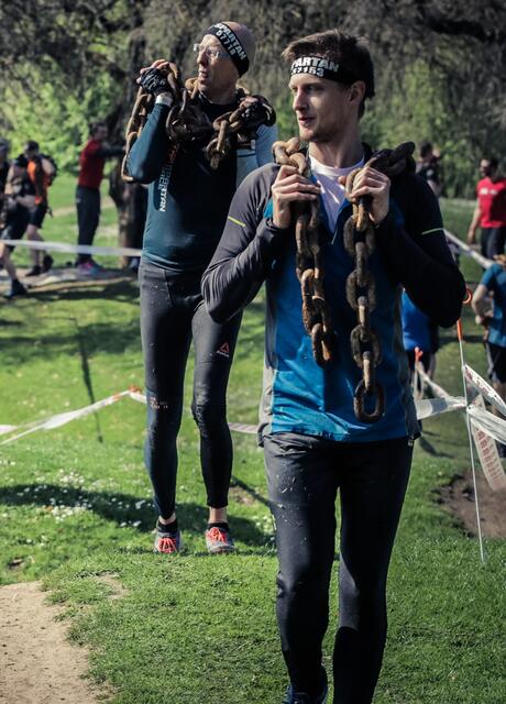 Ca. 20 kg schwere Eisenkette über die Schulter und Parcours hoch und runter laufen