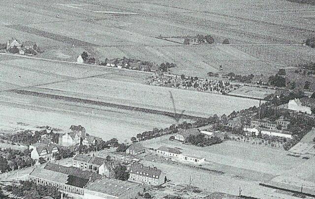 Luftbild. Quer durch das Bild verläuft die Sutelstraße (mit Pfeil >Giesecke-Hof). Links oben ist die neue Schule an der Ebelingstraße zu sehen. Ganz oben: Roschersburg an der Sündernstraße, um 1925.