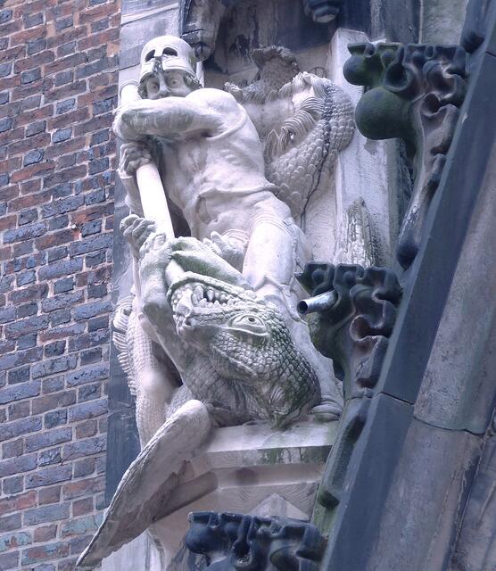 Links des Kirchenportales sieht man den heiligen Georg, der den Drachen tötet. Er war der Namenspatron der Vorgängerkirche.
