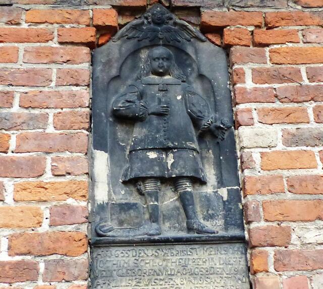 Ein Stück links davon sieht man im Mauerwerk einen Chorknaben. Und natürlich denkt man dabei an die Sage von dem Chorknaben, der beim Taubeneier sammeln vom Turm herabstürzte. Durch seinen sich öffnenden Umhang überlebte er den tiefen Fall.