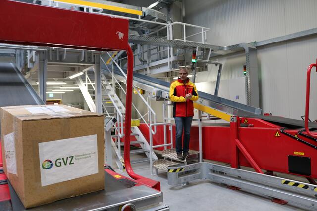Ulrich Brückner, Produktionsleiter der DHL in Neusäß, erläutert, was in der Halle des Paketzustelldienstes geschieht, bevor das Paket auf die Reise geht