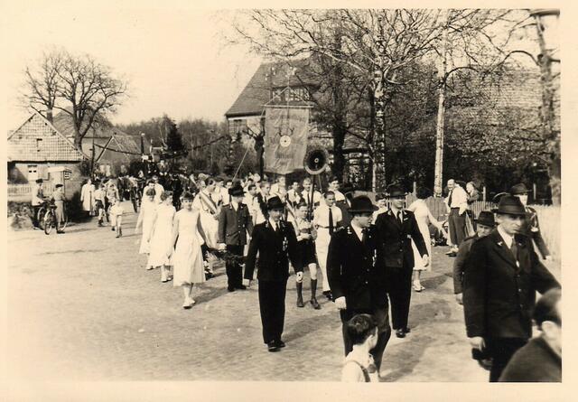 Marsch durch die Straße Schmiedeberg mit Gastwirtschaft Halberstadt, altes Bauernhaus Halberstadt, ehemaliger Brinksitzerhof und Schmiede Gries (links), rechts = Bendix (großes Haus, heute Stadali) und ehemaliges Bösch-Haus mit Friseur Rowold, heute Stadali), um 1955