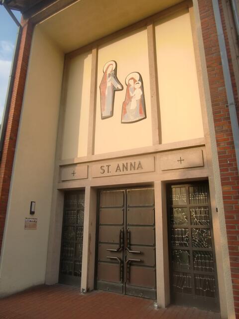 Eingang St.Anna-Kirche, St. Anna, welche als Mutter Mariens gesehen wird, die Namenspatronin der Kirche.Solche Darstellungen , Maria mit dem Kinde und Mutter Anna werden oft Maria Selbstdritt genannt.