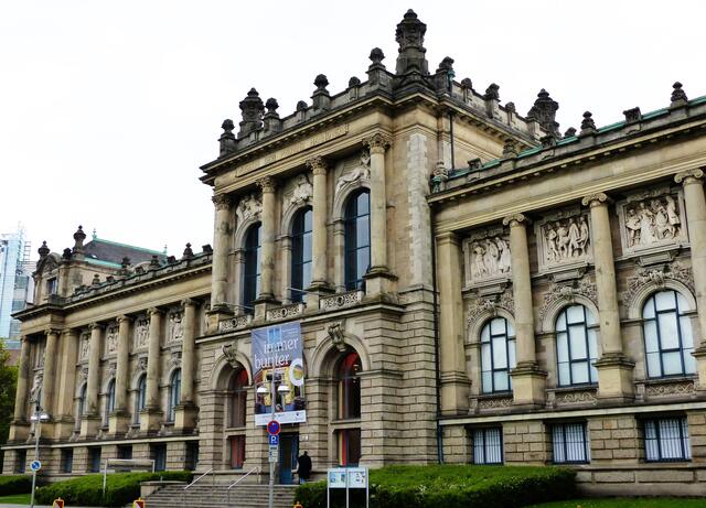 Oben an der Fassade des Landesmuseums Hannover ist die Menschheitsgeschichte im Zeitraffer in 10 Motiven in Stein gemeißelt.