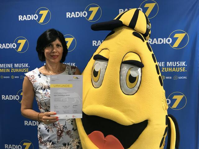 Freuen sich über die Auszeichnung: Ursula Schuhmacher, Leiterin Radio 7 Drachenkinder und DRAKI, das Drachenkinder-Maskottchen. | Foto: Radio 7