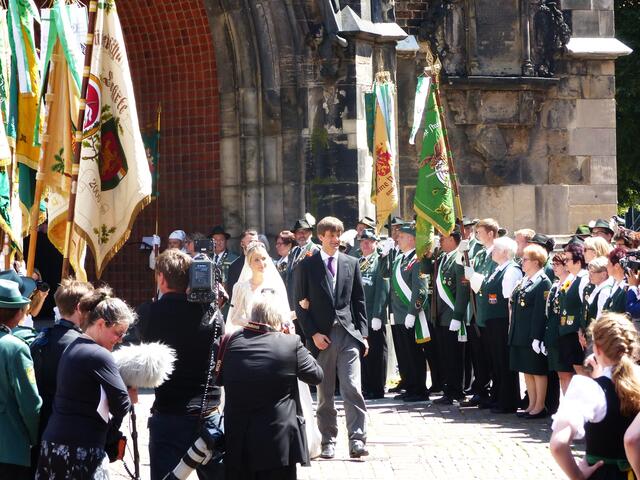 Unter den Begrüßungsklängen des Blashornjägerkorps "Zum Großen Freien" erscheint ein gelöstes Brautpaar am Portal.