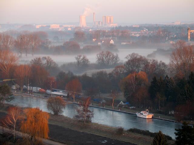 Über den zugefrorenen Leineverbindungskanal geht der Blick über den Morgennebel der nördlichen Leineaue nach Stöcken. Dort dampft das Kohlekraftwerk am Mittellandkanal.
