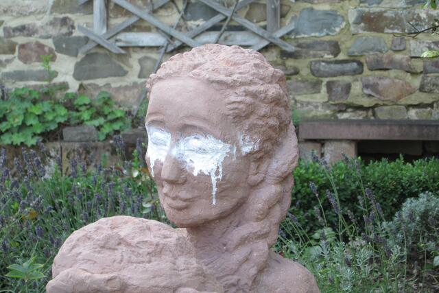 Hier das besprühte Gesicht der Sandsteinskulptur "Die Brotspenderin".