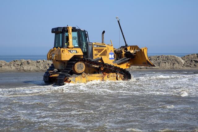 Die Raupen und Maschinen werden durch das Salzwasser und den schmirgelnden Sand stark belastet.