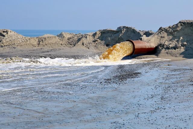Und schon donnern viele tausend Liter Wasser mit Sand aus dem dicken Rohr.