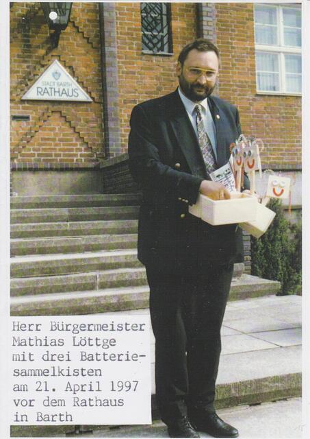 Herr Bürgermeister Mathias Löttge mit drei Batteriesammelkisten am 21. April 1997 vor dem Rathaus Barth (Ostseee)