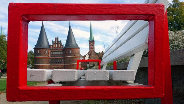 Mit seinen zwei Wehrtürmen zählt das Holstentor zu den beeindruckenden Stadttoren Deutschlands (rechts St. Petri). Foto: Helmut Kuzina