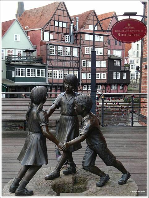 Die Skulptur „La vita è bella“ – „das Leben ist schön“ zeigt drei spielende Kinder auf einem historischen Mühlstein an der Lüner Mühle in Lüneburg (Foto: Katja Woidtke)