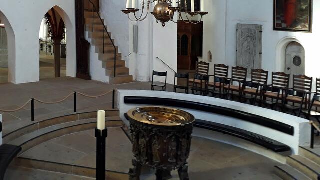 Einen zentralen Platz hat die gotische Bronzetaufe aus dem Jahr 1455, die der Erzgießer Lorenz Grove schuf. Foto: Helmut Kuzina