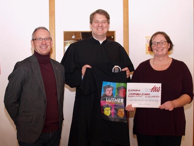 Nachhaltige Wirkung: Pater Brühl freut sich über das Luther T-Shirt zur Erinnerung und über 1000 Euro, die das Publikum nach dem erfolgreichen Pop-Oratorium gespendet hatte. Freude daran hatten auch Beate Anton und Andreas Weindl in Vertretung des gesamten Teams.