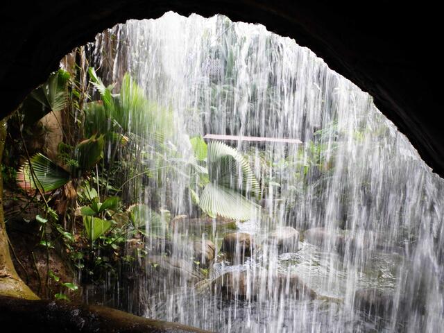 Hinter einem 12 Meter hohen Wasserfall führt der Weg durch eine Höhle.