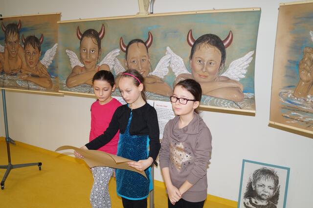 Sara, Mia-Sophie und Tara beim Vortragen ihrer Kinderrechte vor ihren Porträtzeichnungen