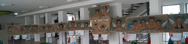 Die Klasse 3b als Engelchen und Teufelchen auf 14 Metern, gezeichnet von Tomé, in der Aula der Schule