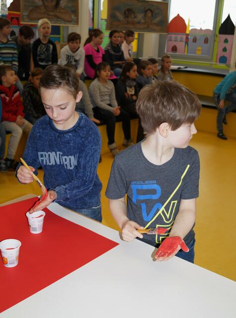 Eliah und Leon malen ihre Hand rot an