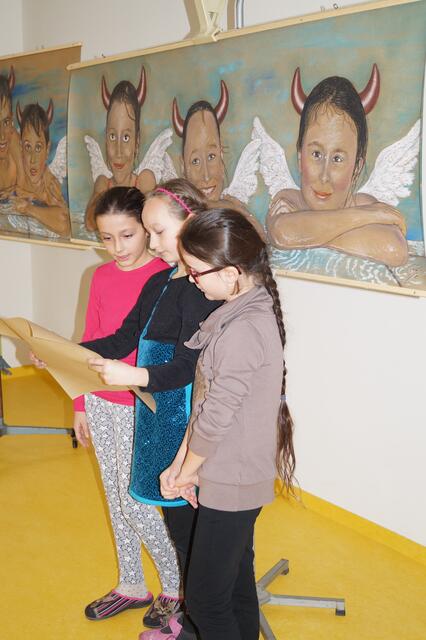 Sara, Mia-Sophie und Tara beim Vortragen ihrer Kinderrechte vor ihren Porträtzeichnungen