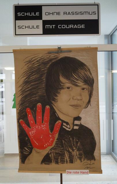 Jonas mit seiner roten Hand in der Aula der Eichenwaldschule, eine Schule ohne Rassismus und mit Courage