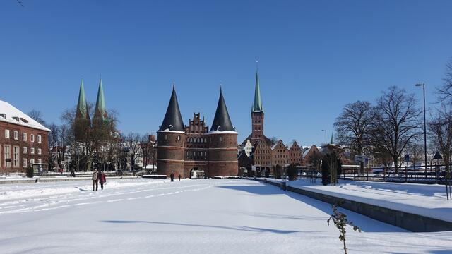Der Holstenplatz, (von links) Marienkirche, Holstentor, Petrikirche, Salzspeicher. Foto: Helmut Kuzina