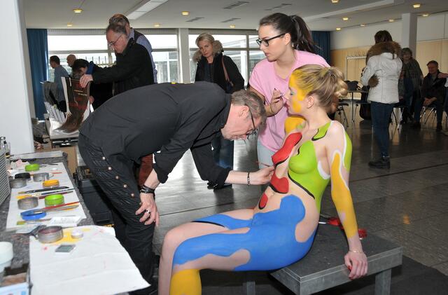 Model Serina wird von Jörg Düsterwald und Assistentin Sonia in bunten Farben gehüllt.