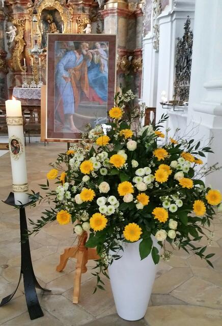 Kerze, Blumenschmuck und Bild zum Josefstag
