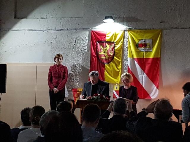 Natasa Jakopin beaufsichtigt feierlich die Unterschriften der beiden Schulleiter Thomas Kelber und Mateja Rozman.