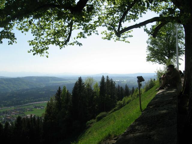 Im Schatten der mächtigen Bäume vor der Kirche: Logenplatz ersten Ranges auf der Hofmauer am Hohenpeißenberg.