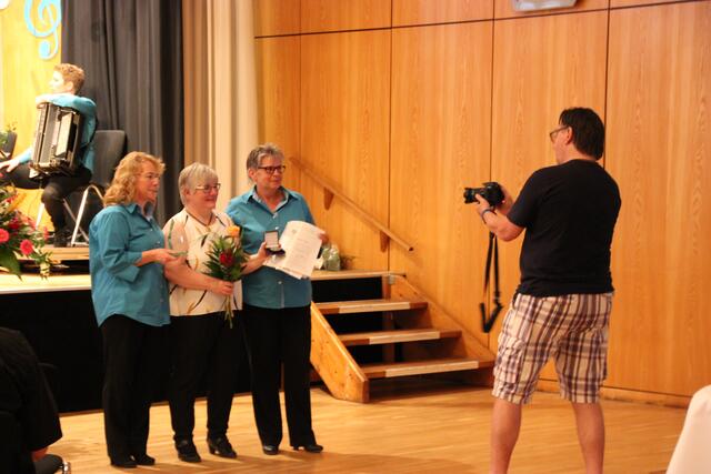 Die Vorsitzenden Cordula Pütz und Anke Simon und die Dirigentin Angelika Nikolai (mitte) präsentieren die Auszeichnungen des Deutschen Harmonika-Verband e.V.