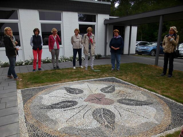 . . . Marion Burk,li., Küsterin der Martin-Luther-Kirchengemeinde, stellte den neugestalteten Luthergarten mit dem Lutherrosen-Mosaik und dem Luthernagel vor . . .