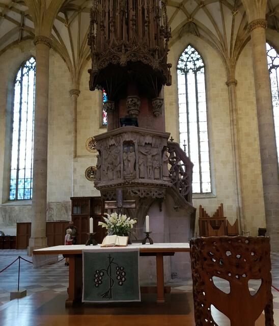 Wie ein riesiger Turm schraubt sich die Kanzel im Ulmer Münster Richtung Decke. Im Inneren kann man eine kleine Wendeltreppe sehen, die zu einer kleinen Kanzel führt. Hier hat Gott symbolisch seinen Platz – als unsichtbarer, himmlischer Prediger.