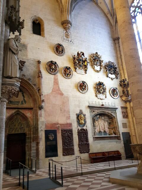 Über 100 aufwendig geschnitzte Totenschilde hängen im Ulmer Münster. Mit ihnen wird auch der bürgerliche Charakter des Kirchenbaus deutlich. Patrizier durften diese Schilde seit dem 15. Jahrhundert in der Kirche aufhängen, wenn ein Familienmitglied gestorben war.