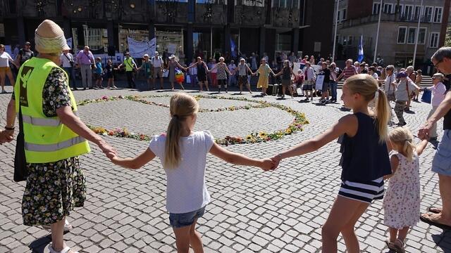 Zum Abschluss der Mahnwache bildeten etliche Teilnehmerinnen und Teilnehmer um das Peace-Zeichen herum einen Menschenkreis, um unter Anleitung von Helene Streicher einen Ulmentanz durchzuführen.