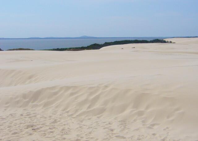 Im Hintergrund der riesige Lebasee, ein abgeschnittener Teil der Ostsee. Auf der Nehrung zwischen See und Meer liegt das Dünengebiet.